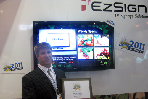 LG EZSIGN TV Infocomm 2011 Winner A gentleman holds up a plaque for the BEST Award in front of the LG EZSIGN TV installation at InfoComm 2011.