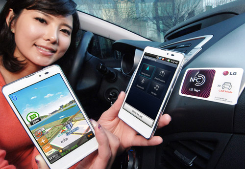 A woman holds two LG Optimus LTE Tags and shows their front views inside a car