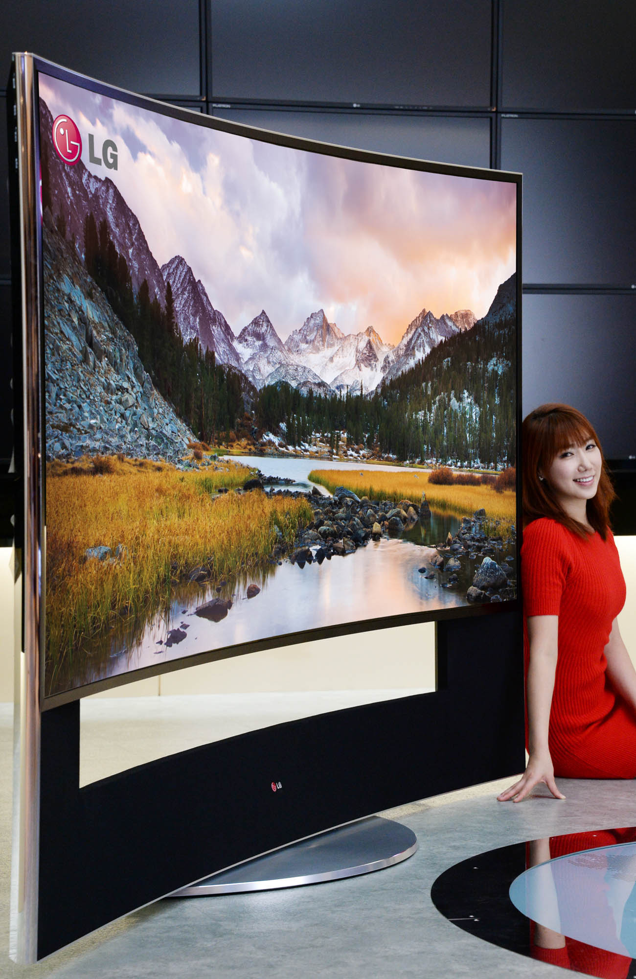 A model leans on the edge of LG 21:9 aspect ratio CURVED ULTRA HD TV model 105UC9 at CES 2014