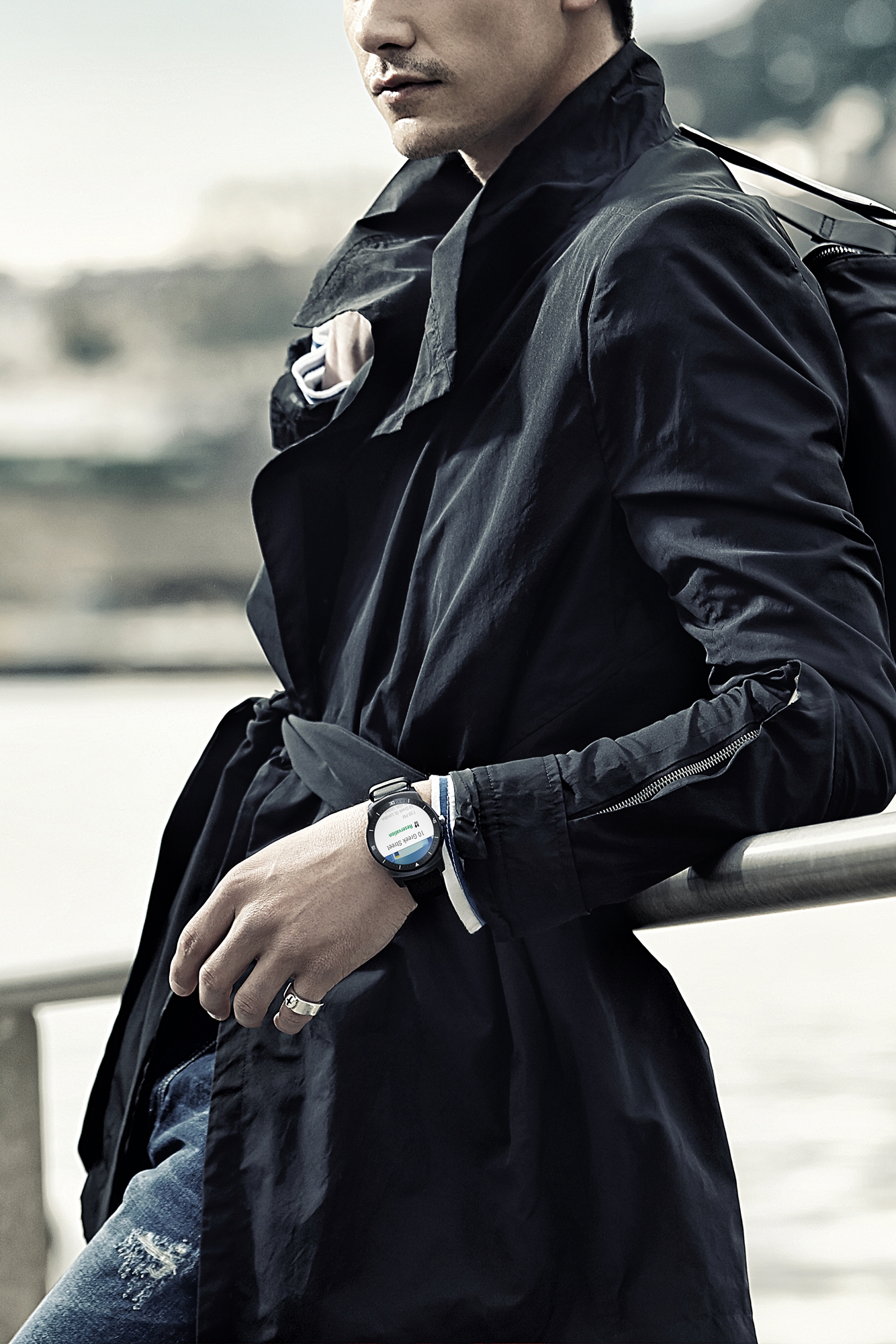 A man wearing the LG G Watch R. as he leans over a rail.