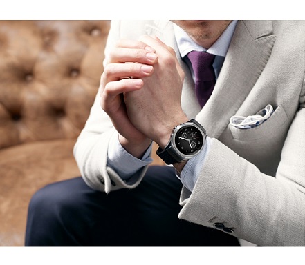 A man in suit holds his hands wearing LG Watch Urban LTE on the left hand.