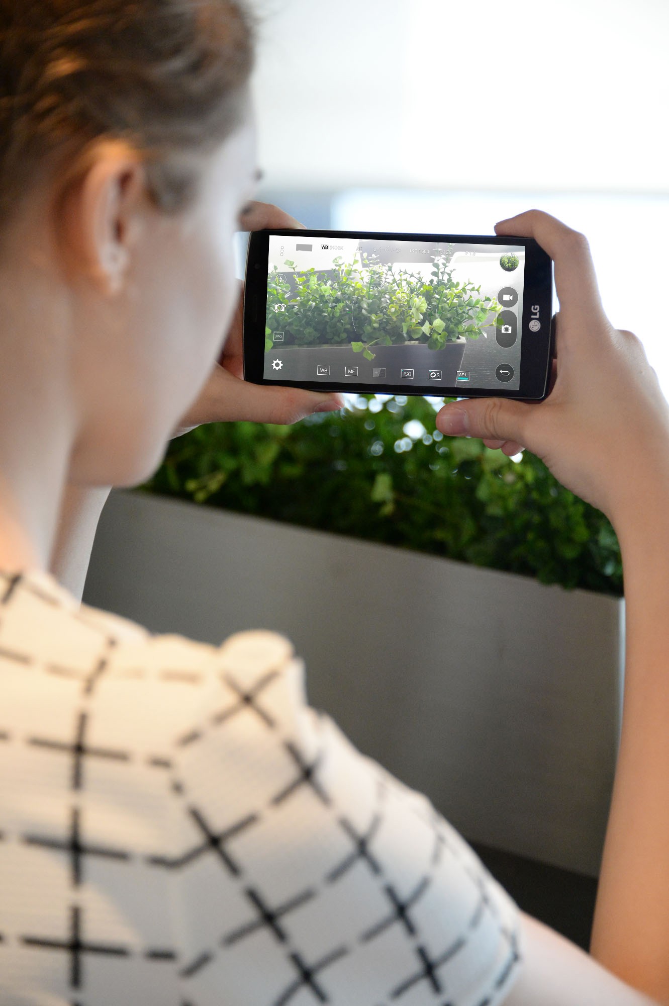 A woman taking a landscape picture with the LG G4 Beat.