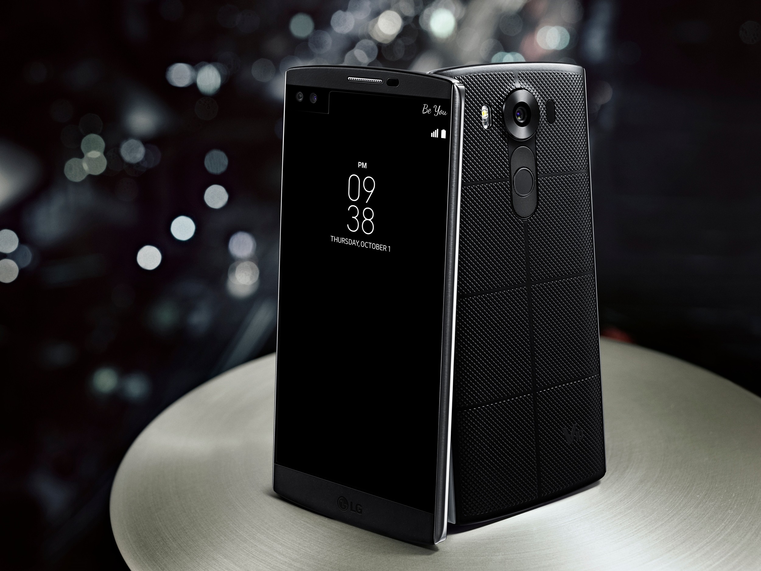 Two LG V10s in Space Black standing on a table, showing the front and back view of the device