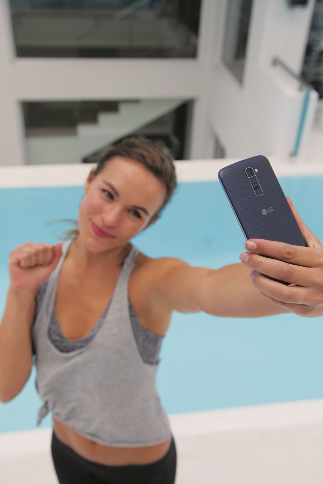 A woman is taking a selfie with the LG K10 in Indigo