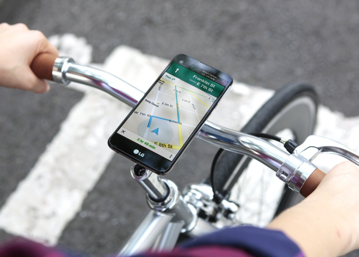 A biker is receiving directions from the LG X screen, which is fixed on the top of the bike handle