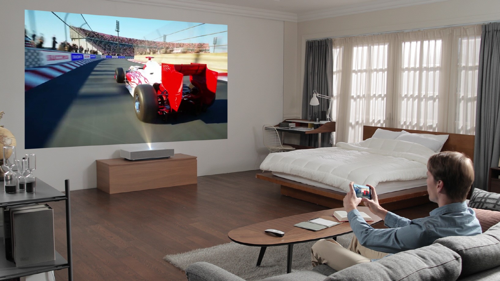 A man playing a video game with the LG CineBeam Laser 4K projector model HU85L