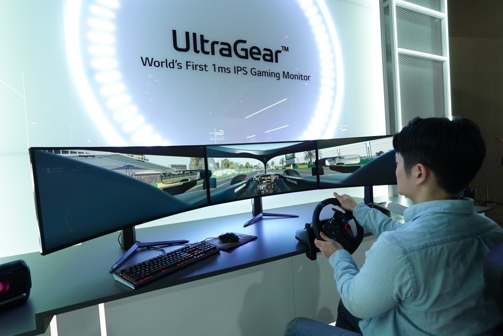 A man uses three wide LG UltraGear monitors side-by-side to experience an immersive racing game setup at CES 2020 with record-breaking 1ms response rates