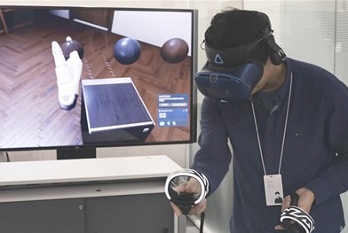 One of LG’s digital designers using a VR headset and remote control to better understand a product’s ability to harmonize with the environment.